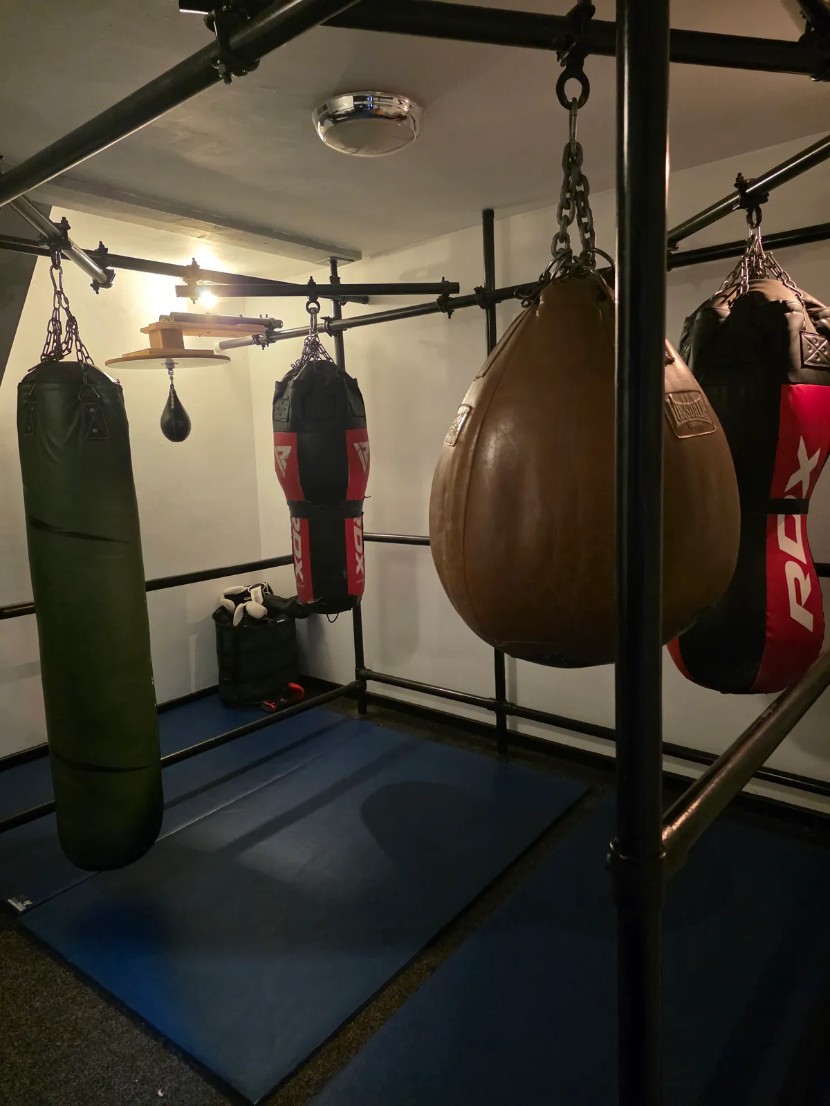 The boxing room at Studio 20, with heavy bags, a leather teardrop bag and a speedball rigged to a scaffold frame